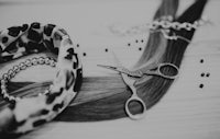 a black and white photo of a pair of scissors and beads