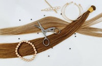 a pair of scissors, a pair of scissors, and a pair of long brown hair